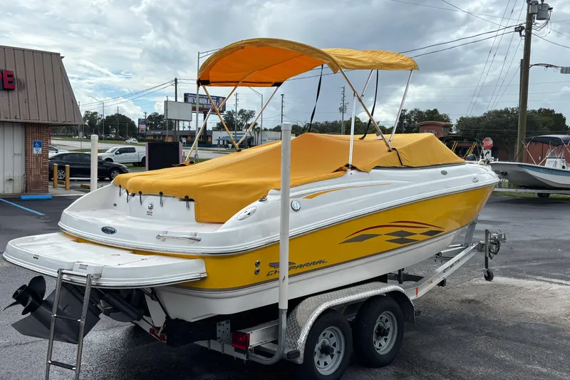 Slide: The Image of 2004 Chaparral 210 SSi boat with yellow cover on trailer, parked outdoors. - 44