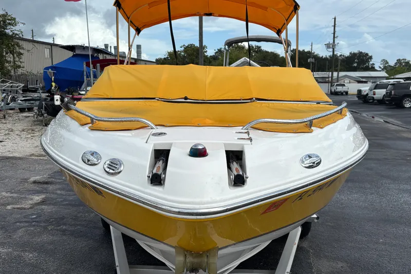 Slide: The Image of 2004 Chaparral 210 SSi boat with yellow cover and canopy, parked outdoors. - 45