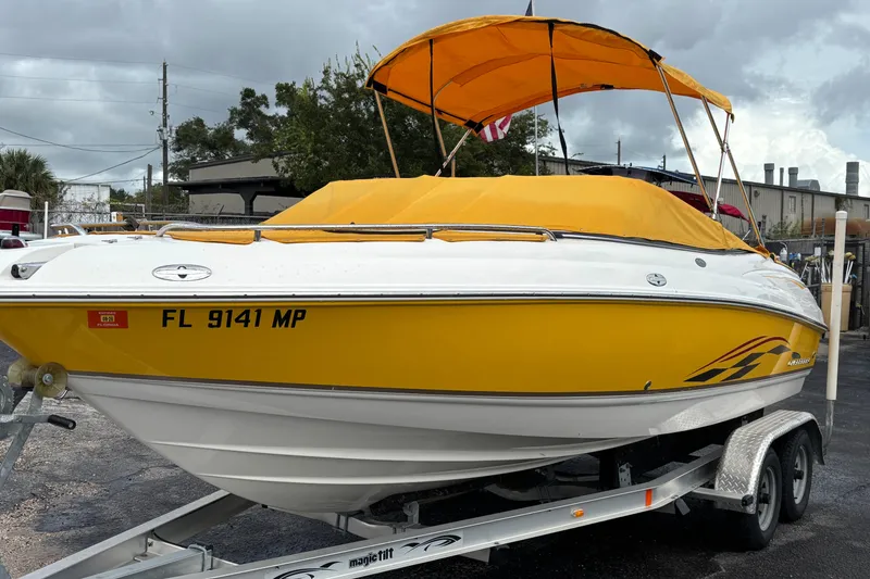 Slide: The Image of 2004 Chaparral 210 SSi boat with yellow cover on trailer, parked outdoors. - 46