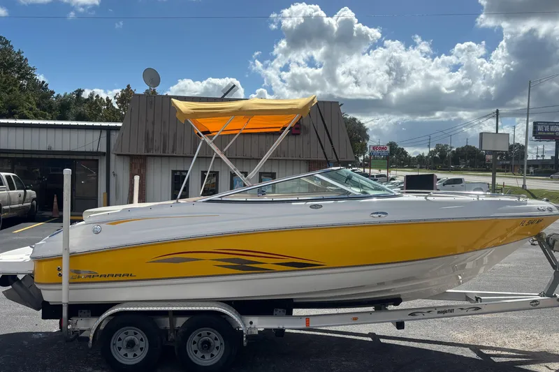 Slide: The Image of 2004 Chaparral 210 SSi boat with yellow accents on a trailer, parked outdoors. - 5