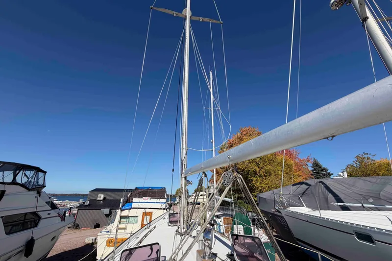 Slide: The Image of 1983 Hinterhoeller Niagara 35 sailboat docked, surrounded by other boats, under clear blue sky. - 10