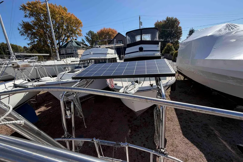 Slide: The Image of 1983 Hinterhoeller Niagara 35 sailboat with solar panel, docked among other boats. - 13