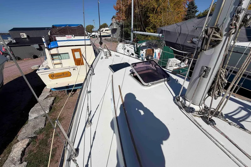 Slide: The Image of 1983 Hinterhoeller Niagara 35 sailboat on land, surrounded by other boats and autumn trees. - 14
