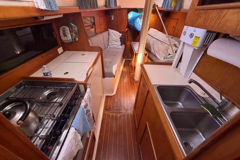 Slide: The Image of Interior of 1983 Hinterhoeller Niagara 35 sailboat with kitchen and seating area. - 18