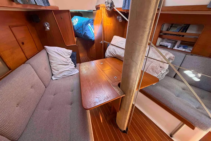 Slide: The Image of Interior of 1983 Hinterhoeller Niagara 35 sailboat with cozy seating and wooden table. - 22
