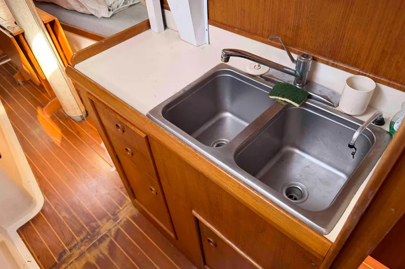 Slide: The Image of 1983 Hinterhoeller Niagara 35 yacht kitchen with double sink and wooden cabinetry. - 24