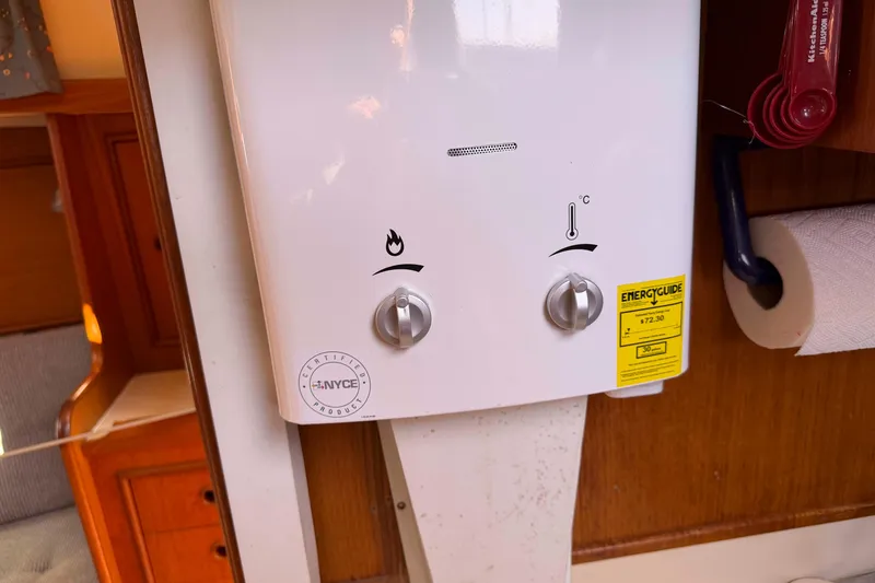 Slide: The Image of 1983 Hinterhoeller Niagara 35 interior with wall-mounted water heater and energy guide label. - 26