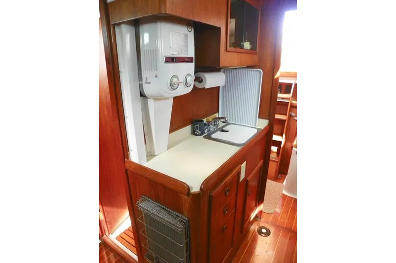 Slide: The Image of 1983 Hinterhoeller Niagara 35 yacht interior with wooden cabinetry and compact kitchen area. - 27