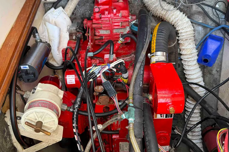 Slide: The Image of Engine compartment of a 1983 Hinterhoeller Niagara 35 sailboat, featuring red engine components. - 29