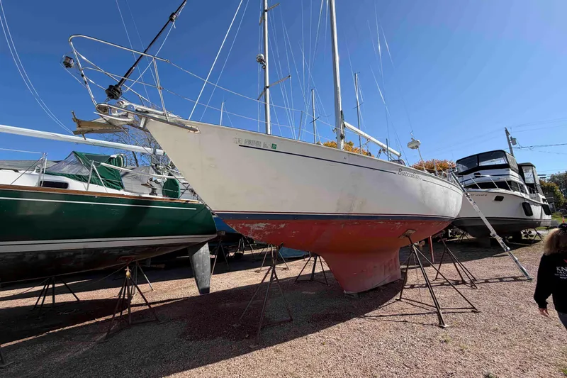 Slide: The Image of 1983 Hinterhoeller Niagara 35 sailboat on stands, displayed outdoors under clear blue sky. - 3