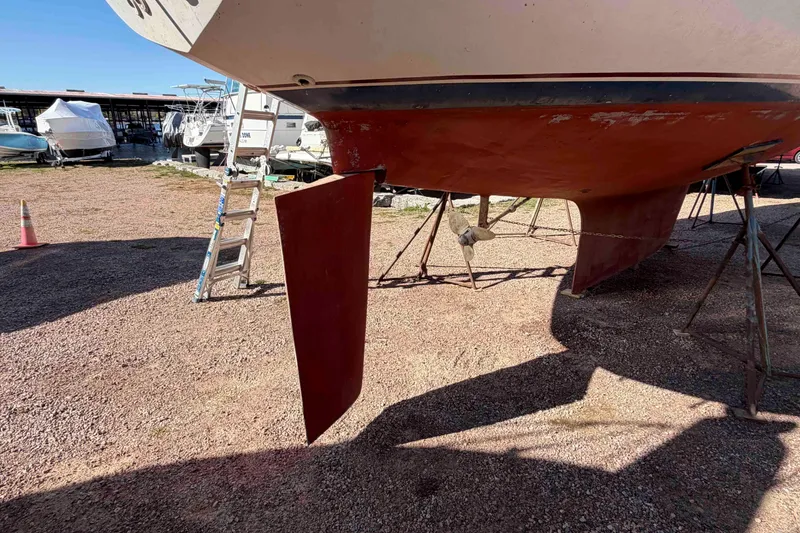 Slide: The Image of 1983 Hinterhoeller Niagara 35 sailboat on dry dock, showing rudder and propeller. - 6