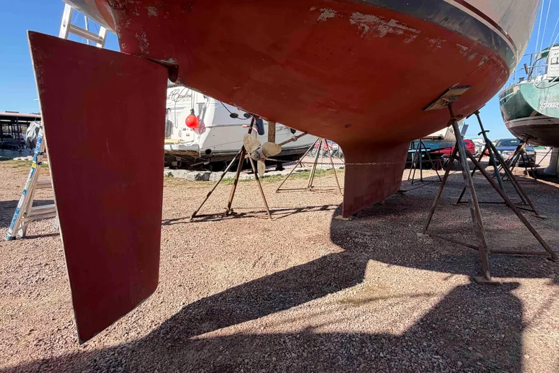Slide: The Image of 1983 Hinterhoeller Niagara 35 sailboat on stands, showing keel and rudder. - 7