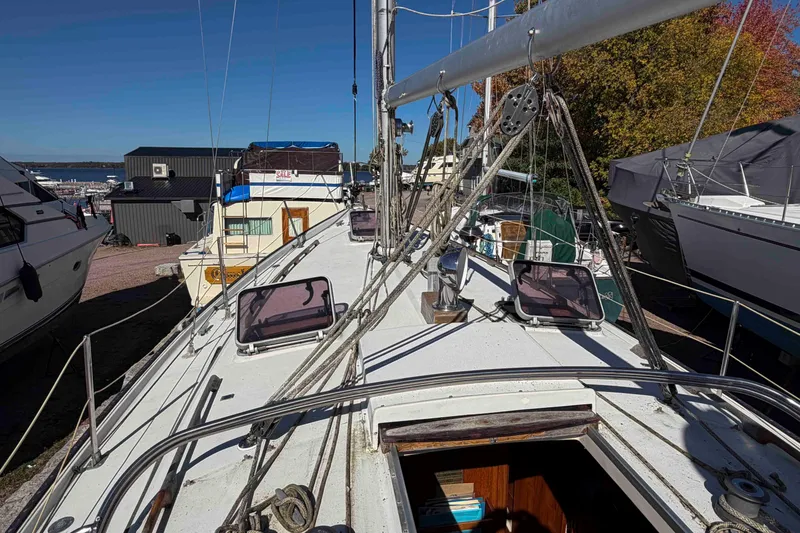 Slide: The Image of 1983 Hinterhoeller Niagara 35 sailboat on land, showcasing deck and rigging details. - 9