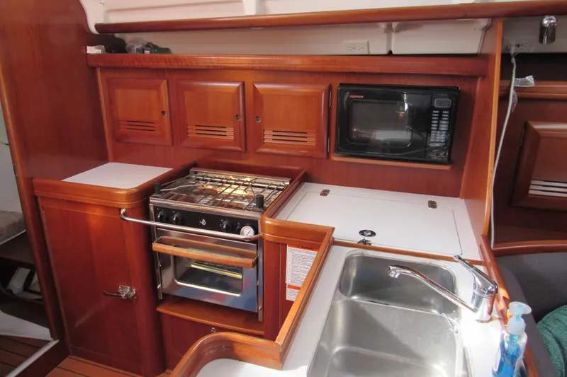 Slide: The Image of Galley kitchen in 2005 Beneteau Oceanis 373 sailboat with stove, microwave, and sink. - 17