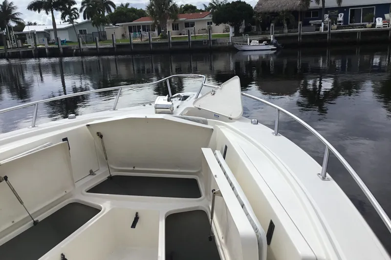 Slide: The Image of 2007 Pursuit C 280 Center Console boat with open storage compartments by a calm waterfront. - 13
