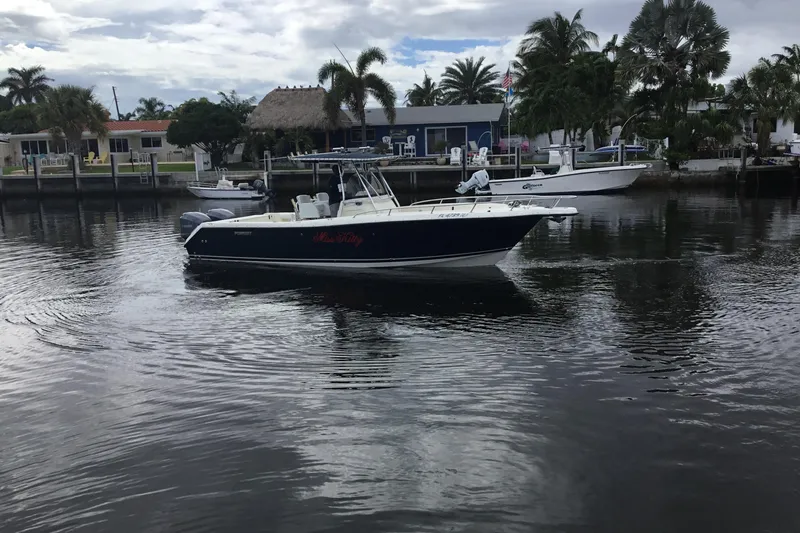 Slide: The Image of 2007 Pursuit C 280 Center Console boat on calm water near docks and palm trees. - 3