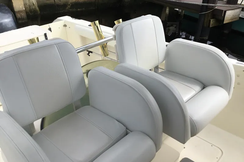 Slide: The Image of 2007 Pursuit C 280 Center Console boat seats, white upholstery, docked setting. - 36