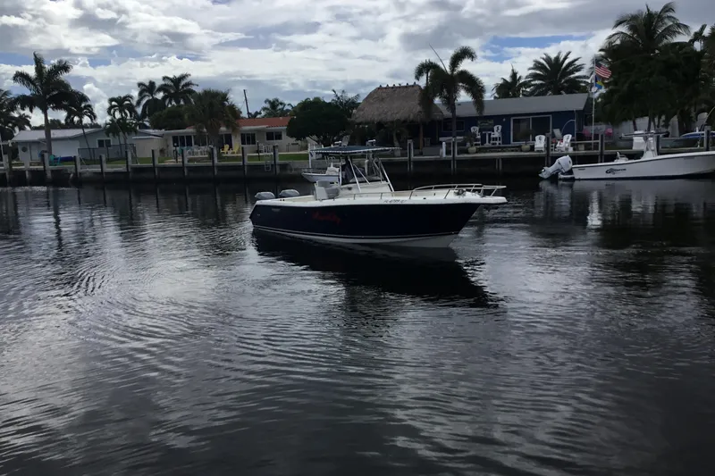 Slide: The Image of 2007 Pursuit C 280 Center Console boat on calm water near a residential dock. - 4