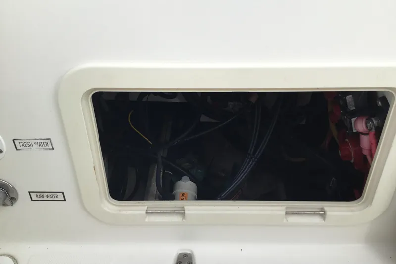 Slide: The Image of 2007 Pursuit C 280 Center Console water access panel with fresh and raw water labels. - 40