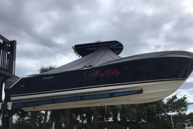 Slide: The Image of 2007 Pursuit C 280 Center Console boat named "Miss Kitty" on a lift under cloudy skies. - 50
