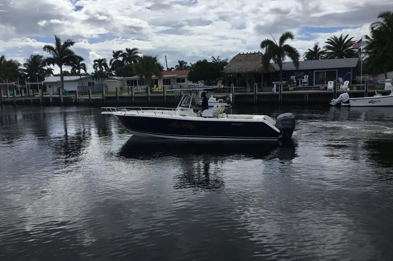 Slide: The Image of 2007 Pursuit C 280 Center Console boat on calm water near a dockside community. - 9