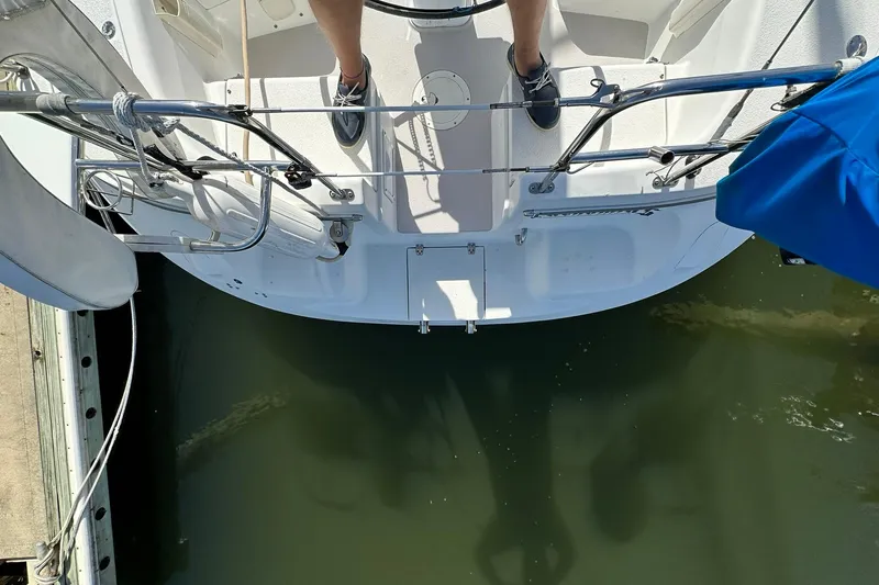 Slide: The Image of Catalina 320 sailboat stern view, docked, with person standing on deck, 2008 model. - 14