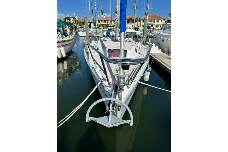 Slide: The Image of 2008 Catalina 320 sailboat docked in marina, front view with anchor visible. - 17