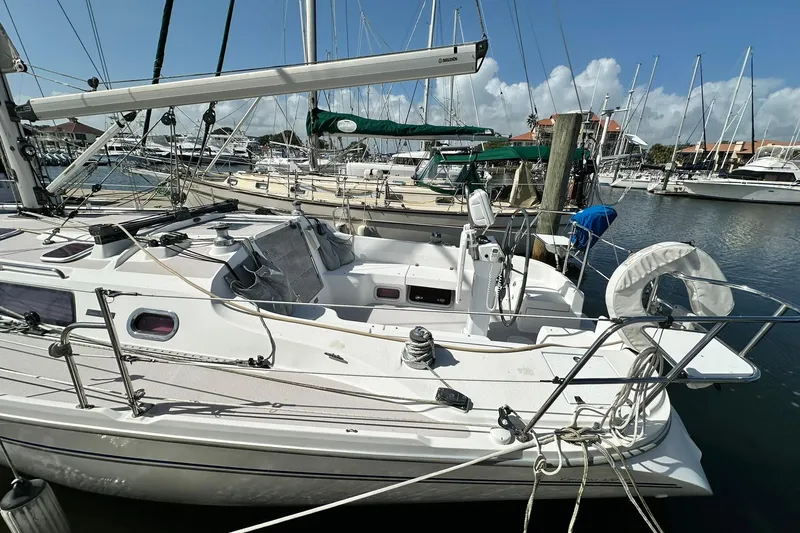 Slide: The Image of 2008 Catalina 320 sailboat docked at marina under clear blue sky. - 23