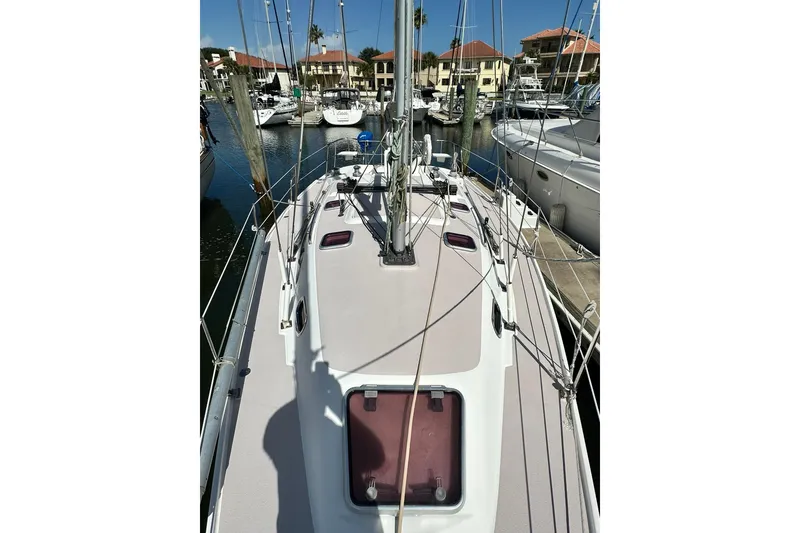 Slide: The Image of 2008 Catalina 320 sailboat docked in a marina, surrounded by other boats. - 26
