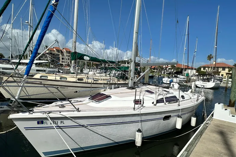Slide: The Image of 2008 Catalina 320 sailboat docked at marina under clear blue sky. - 3