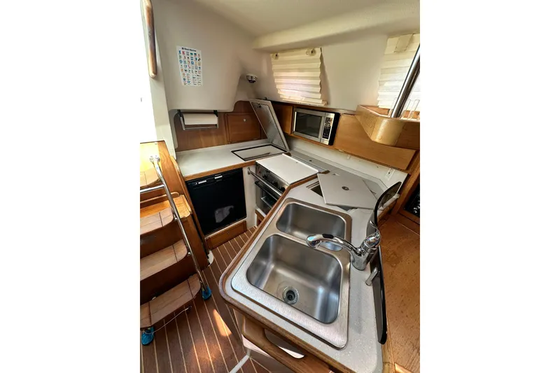 Slide: The Image of Compact kitchen in a 2008 Catalina 320 sailboat with sink, stove, and microwave. - 38