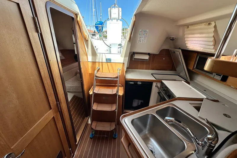 Slide: The Image of Interior of 2008 Catalina 320 sailboat with kitchen, sink, and wooden cabinetry. - 39