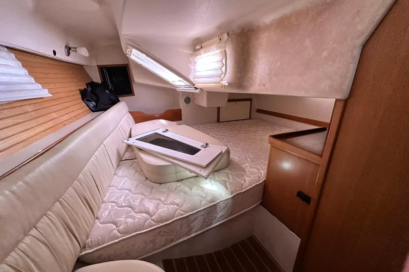 Slide: The Image of Interior cabin of a 2008 Catalina 320 sailboat with cozy bedding and storage. - 42