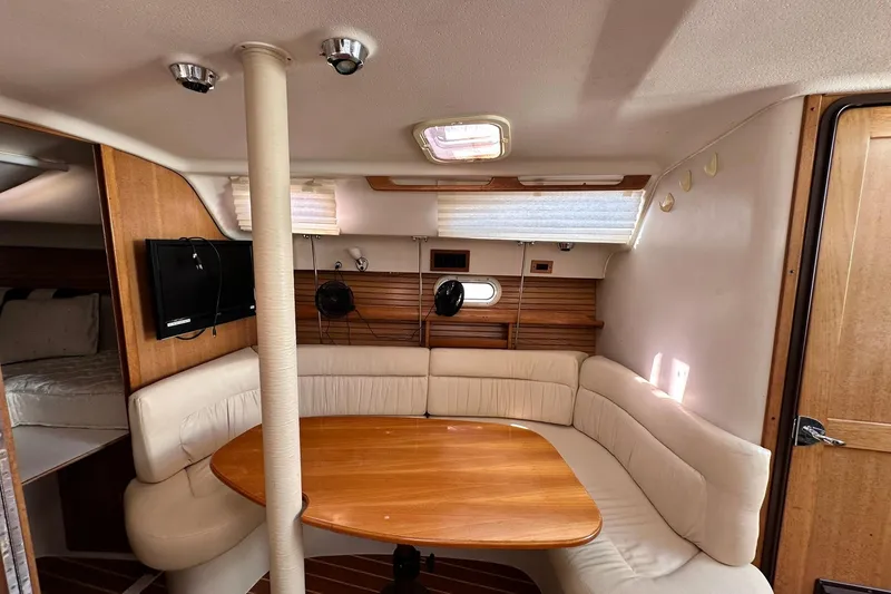 Slide: The Image of Interior of 2008 Catalina 320 sailboat with cozy seating and wooden table. - 52