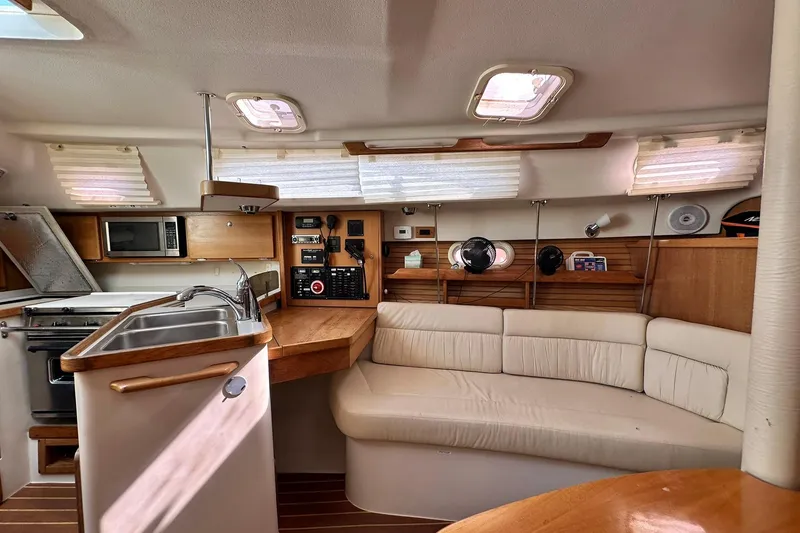 Slide: The Image of Interior of a 2008 Catalina 320 sailboat with kitchen and seating area. - 53
