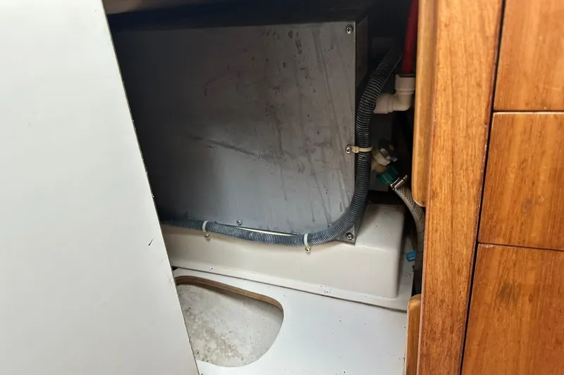 Slide: The Image of Interior view of a 2008 Catalina 320 sailboat, showcasing plumbing and storage area. - 61