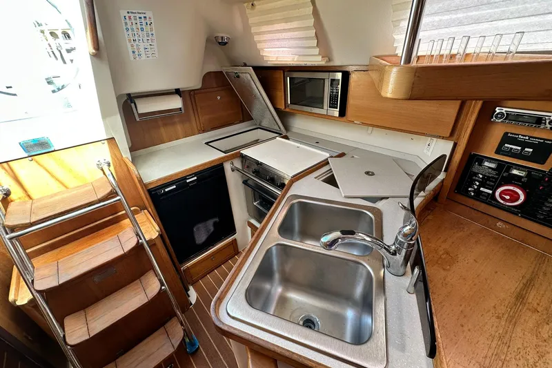 Slide: The Image of Compact kitchen in 2008 Catalina 320 sailboat with sink, stove, and microwave. - 64