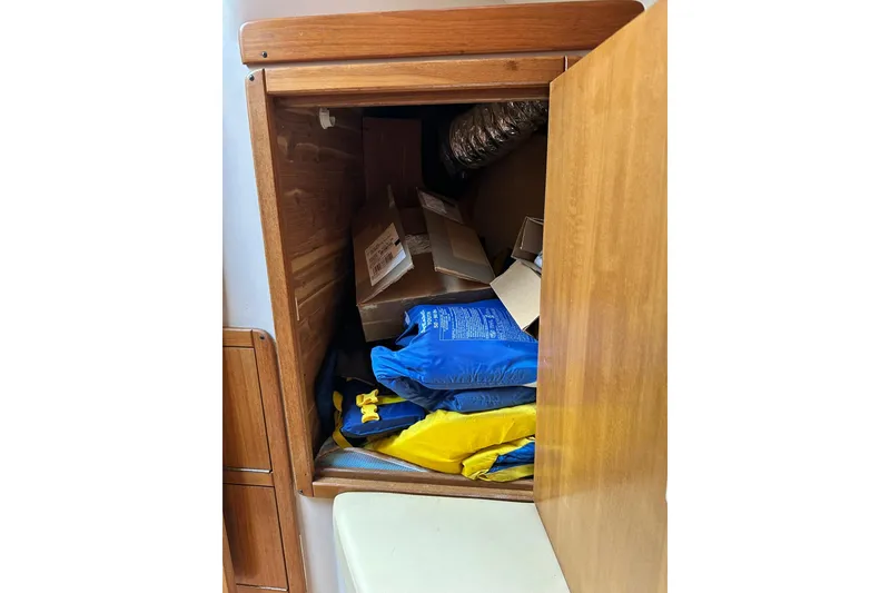 Slide: The Image of Storage compartment in a 2008 Catalina 320 sailboat, containing life jackets and cardboard boxes. - 66