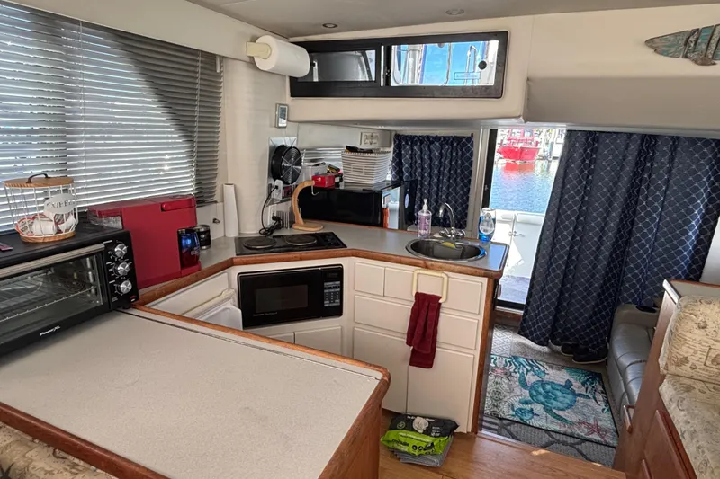 Slide: The Image of Interior of 1993 Carver 350 Voyager with cozy seating and nautical-themed pillows. - 16