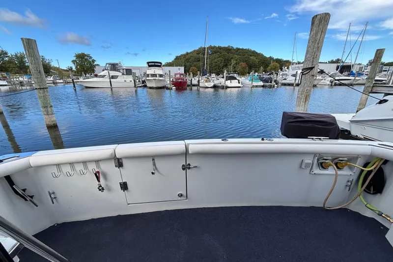 Slide: The Image of 1993 Carver 350 Voyager docked at marina, surrounded by boats and vibrant flowers. - 5