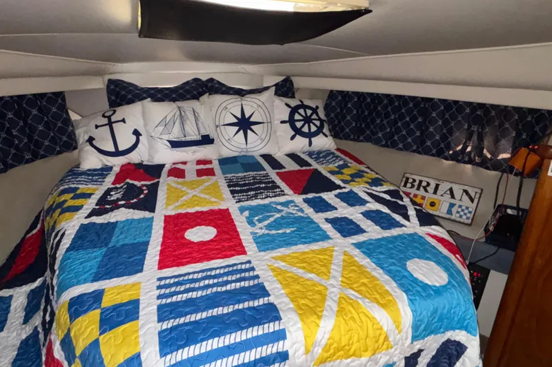 Slide: The Image of Nautical-themed bedroom in 1993 Carver 350 Voyager with colorful quilt and decorative pillows. - 21