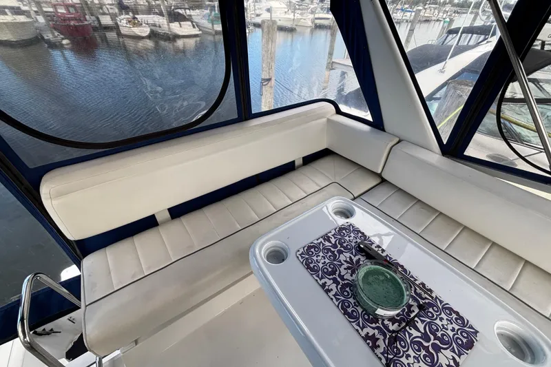 Slide: The Image of Interior of 1993 Carver 350 Voyager yacht with seating and table, marina view. - 33