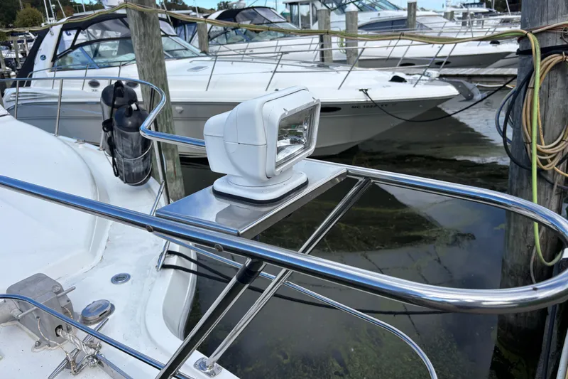 Slide: The Image of 1993 Carver 350 Voyager boat with spotlight, docked among other boats. - 37