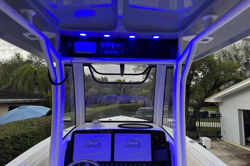 Slide: The Image of 2021 Sea Hunt Gamefish 25 boat interior with blue LED lighting and Garmin electronics. - 18