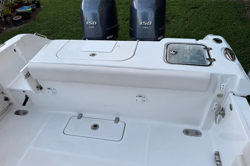 Slide: The Image of 2021 Sea Hunt Gamefish 25 boat deck with Yamaha 150 engines, white seating, and storage compartments. - 6