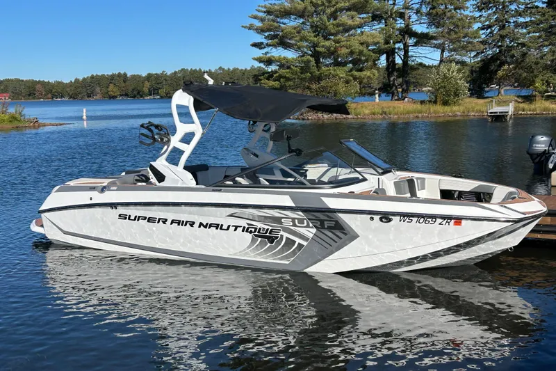 The Image of 2017 Nautique Super Air Nautique G23 boat on a serene lake with trees in the background. - 0