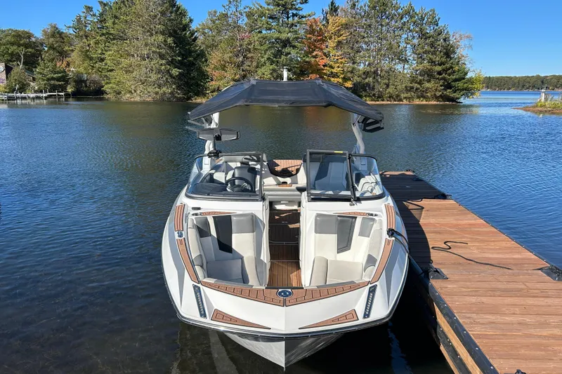 Slide: The Image of 2017 Nautique Super Air Nautique G23 boat docked on a serene lake. - 3