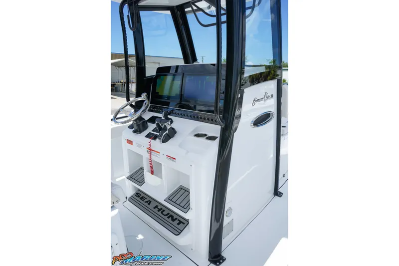 Slide: The Image of 2026 Sea Hunt Gamefish 30 Coffin Box boat console with steering wheel and navigation screens. - 13