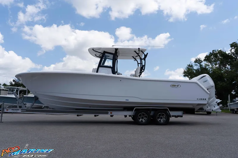 Slide: The Image of 2026 Sea Hunt Gamefish 30 Coffin Box boat on trailer under cloudy sky. - 30