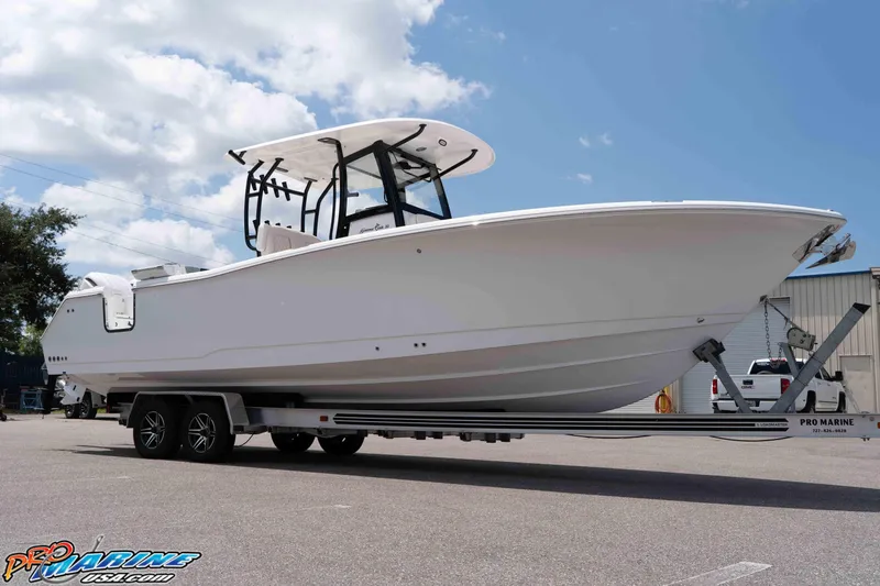 Slide: The Image of 2026 Sea Hunt Gamefish 30 Coffin Box boat on trailer, parked outdoors under blue sky. - 48